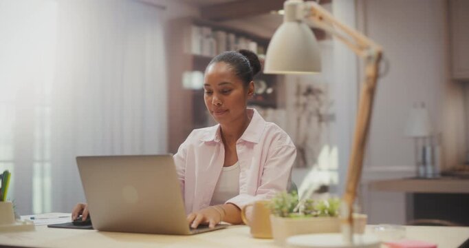 360 Degree. Black Woman Working on Laptop Computer at Cozy Home Desk, Organizing Digital Calendar, Browsing Internet and Completing Remote Freelance Projects in Apartment. Cinematic Arc Tracking Shot.