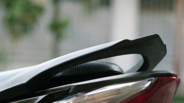Close-up of hand closing a motorcycle scooter seat