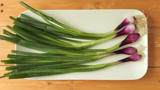 Fresh red spring onion bunch on a plate