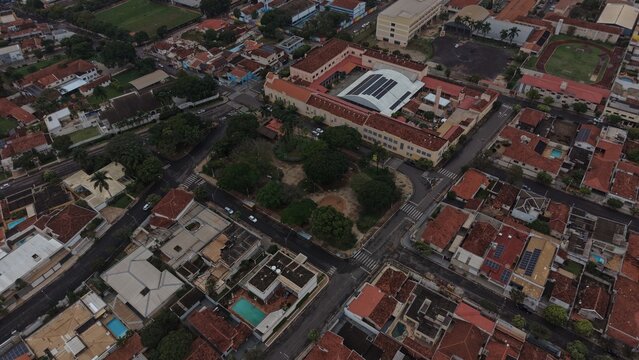 Aerial view of a residential neighborhood with a school and solar panels on rooftops