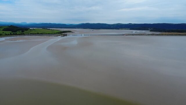 high aerial view of Arnside railway viaduct in Cumbria showing the river Kent running into Morecambe Bay near Grange over Sands