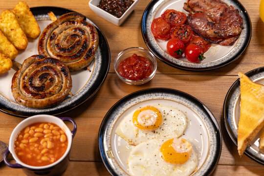 Full English Breakfast Platter with Spiral Sausages, Beans, Eggs, Tomatoes, Bacon, and Toast 2