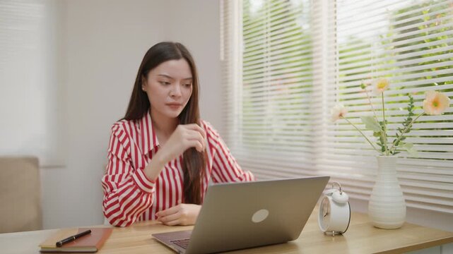 Stressed woman working on a laptop with hands on her head, ideal for deadline pressure, burnout, work overload, office anxiety, mental stress and productivity problems.