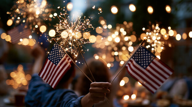 Faceless family waving small American flags under bursting fireworks in a bright evening backyard warm sparkle and atmospheric glow distant composition independence day fourth