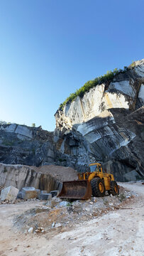 Old abandoned excavator inside a majestic rusty marble stone quarry