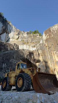Old abandoned excavator inside a majestic rusty marble stone quarry
