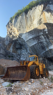 Old abandoned excavator inside a majestic rusty marble stone quarry