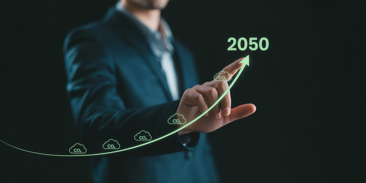 Businessman pointing at 2050 target line with carbon dioxide icons representing net zero emissions goal.