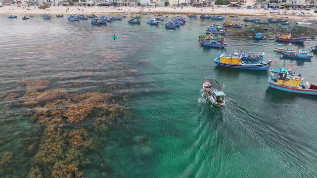 Fishing boats over seaweed reefs at Hon Kho, Quy Nhon, Vietnam