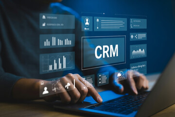 Fototapeta premium Business professional using customer relationship management software interface on laptop with data analytics and charts.