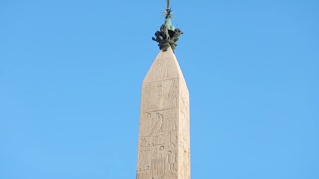 Lateran Obelisk, ancient Egyptian obelisk with Egyptian hieroglyphs, Christian cross with bird on blue sunny sky in Rome in Italy. Topics: antiquity, tourist attraction, archaeology, art, history