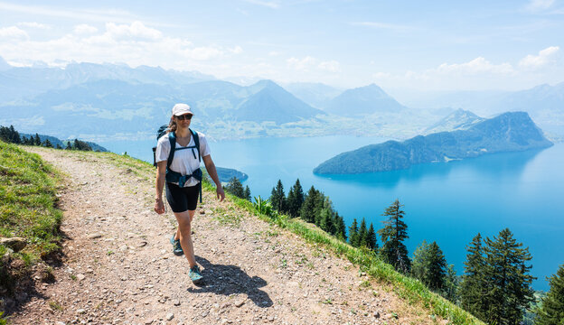 Woman hiking mountain trail overlooking lake lucerne switzerland