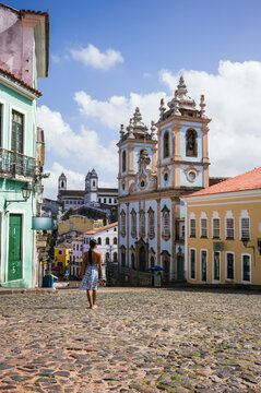 Woman looking at Rosario dos Pretos church on the cobblestone Pelourinho square, Salvador, Bahia, Brazil