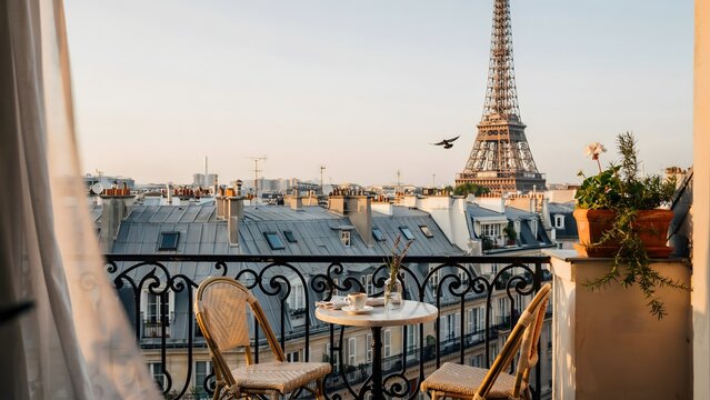 Beautiful Parisian balcony view with Eiffel Tower, plants, and outdoor dining setup