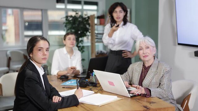 Female businessperson courses visitor at meeting listens to teacher and look to presentation. Off-line training in crisis management courses, students listen to lecturer