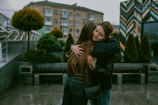 Two female friends walking outdoors on an autumn day