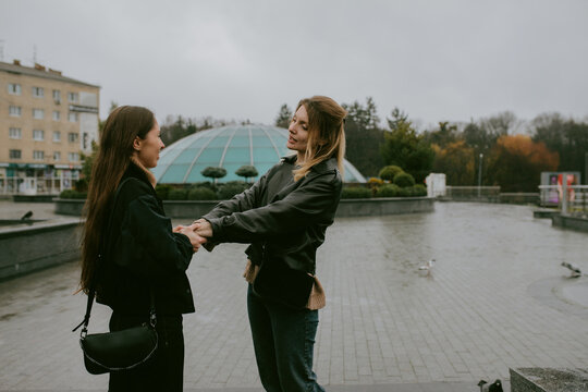 Two female friends walking outdoors on an autumn day