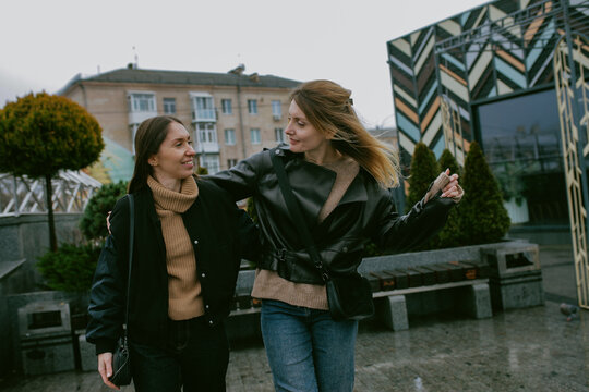 Two female friends walking outdoors on an autumn day