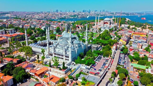 Aerial view of the Blue Mosque in Istanbul, Turkey. The Sultan Ahmed Mosque stands with its domes and minarets near Hagia Sophia, green parks, the Bosphorus and the modern city skyline.