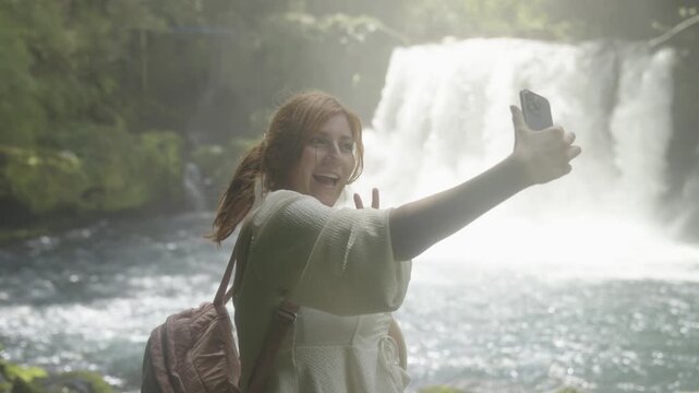 Woman Taking a Selfie in Front of a Waterfall in Southern Chile