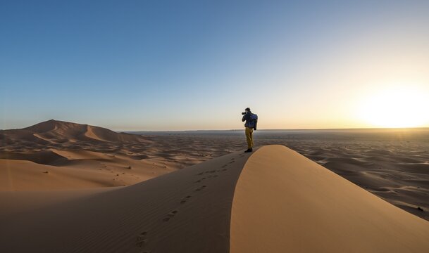 Young man photographed, sand dune, sunrise, Erg Chebbi, Merzouga, Sahara, Morocco