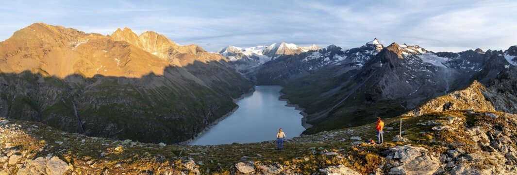 Hikers enjoying the alpine panorama at Lac de Dix, sunset in the mountains, reservoir, Valais Alps, Valais, Switzerland
