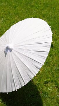 Stylish white vintage umbrellas provide shade from the hot, bright sun on a sunny summer day. Wedding ceremony for the bride and groom.