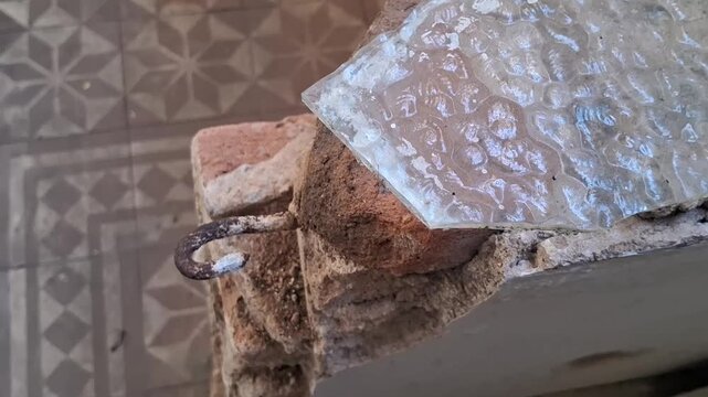 Rusty metal hook embedded in crumbling brick motion video footage