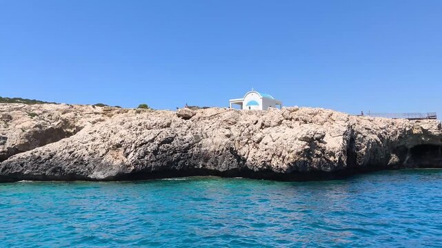  A boat trip along the rocky coast of Protaras, Cyprus, with visit to a white seaside chapel overlooking the Mediterranean Sea. travel, tourism, coastal destinations