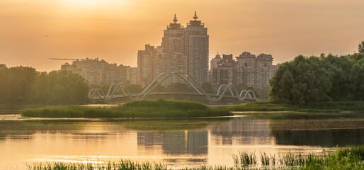 Panoramic view of the modern Wave Bridge and residential towers at golden sunset in Kyiv Obolon Ukraine © underwaterstas