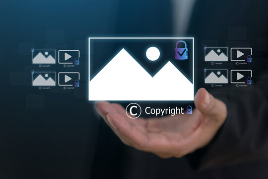Businessman holding virtual copyright icon and photo hologram, Intellectual property protection, digital asset licensing, stock photo video rights and creative content legal ownership system
