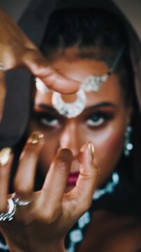 Closeup fantasy african american woman voodoo witch conjuring. Art dance hands. Girl vampire dances hypnotizes with finger slow motion. sexy face. Gothic style Black dress hood vertical video crop.