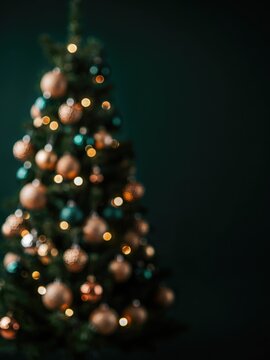 Blurred christmas tree with gold and teal ornaments and bokeh lights