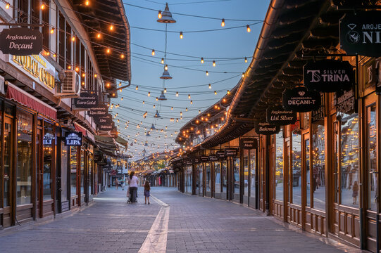 Peja, Kosovo &ndash; June 28, 2026: Empty Bazaar Street with String Lights and Traditional Ottoman Shopfronts at Blue Hour