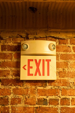 Close Up of Red Exit Sign on Brick Wall of Building