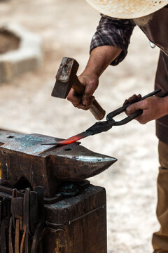 Blacksmith Hammering Glowing Red Iron on Anvil