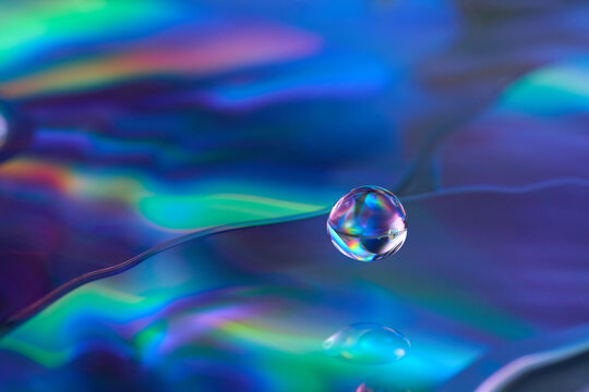 Iridescent water drop on holographic CD surface