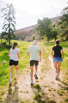 People Running on a Trail in a Green Landscape During the Day