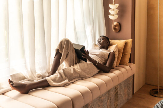 Reading on a Window Bench During a Sunny Afternoon in a Cozy Room