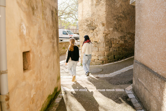 two young women walking in village in the South of France