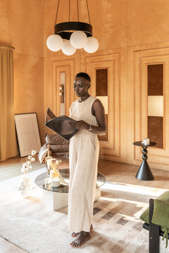 Woman Reading in Stylish Room With Warm Colors and Modern Decor