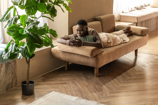 Relaxing on a Couch While Using a Smartphone in a Cozy Room