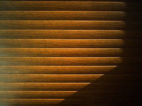 Illuminated wooden closed blinds dramatic sunlight background