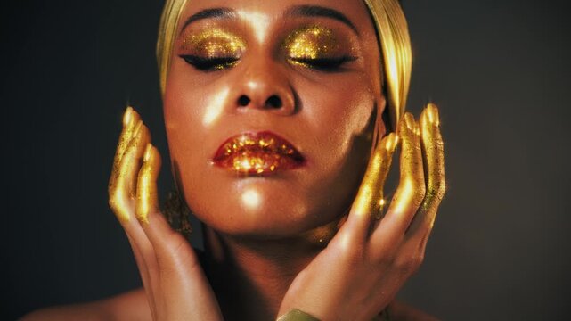 Portrait Beauty fantasy african happy woman smiling faceeye shadow gold paint. Golden makeup liquid gold shiny skin. Fashion model girl. arab turban on head earrings necklace set gold metal jewelry 4k