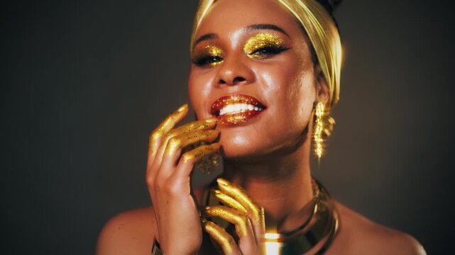 Portrait Beauty fantasy african happy woman smiling faceeye shadow gold paint. Golden makeup liquid gold shiny skin. Fashion model girl. arab turban on head earrings necklace set gold metal jewelry 4k