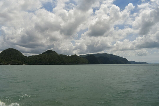 panoramic view of lush tropical green mountains and forested hills along the sea coast of khanom shoreline under a cloudy sky