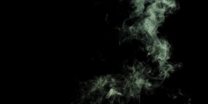 Vapor like smoke on a dark black background. Vape smoke rings in motion at vape clouds.