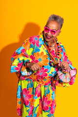Obraz premium Senior woman smiling embracing vibrant fashion and happiness - Old hispanic grandmother wearing fashionable modern clothing on colorful background, concepts about elderly, aging, diversity 