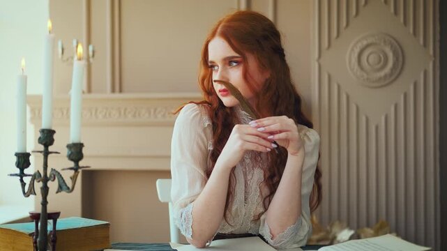 Portrait red-haired vintage woman writer holding bird feather in hands. Medieval girl sit at table writes book, letters on sheets paper with ink pen. Photo old retro style. White blouse, classic room.
