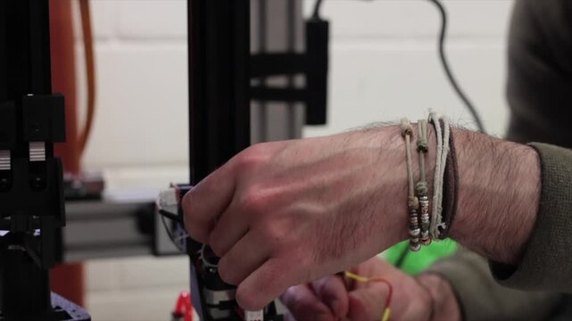 giovane operatore tecnico che lavora su dei macchinari robotici avanzati, video dettagliato in tempo reale